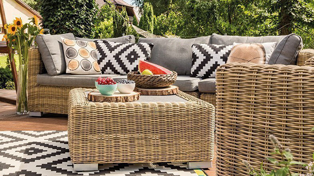 Gemütliche Gartenmöbel mit bunten Kissen auf einer Terrasse