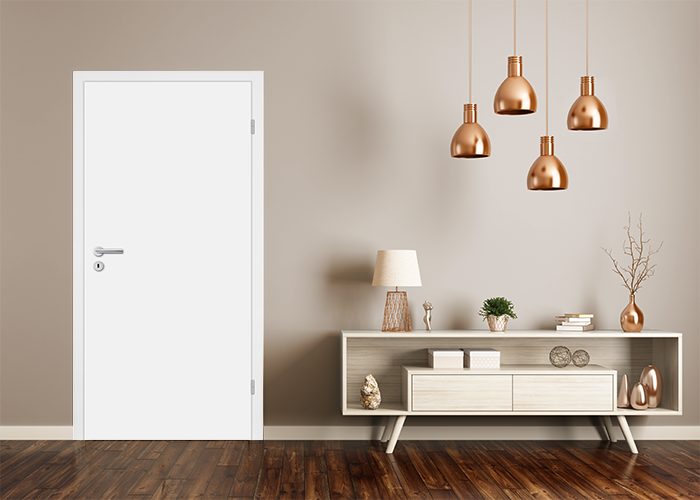 Innentür in Weiß vor einer hellen Wand platziert, umgeben von dekorativen Accessoires.
